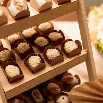 Close-up of Brazilian brigadeiros elegantly arranged on a wooden display at a São Paulo event.