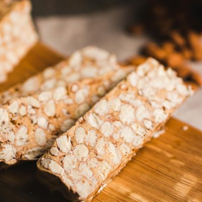 Close-up of peanut nougat bars on a wooden cutting board, showcasing their texture.