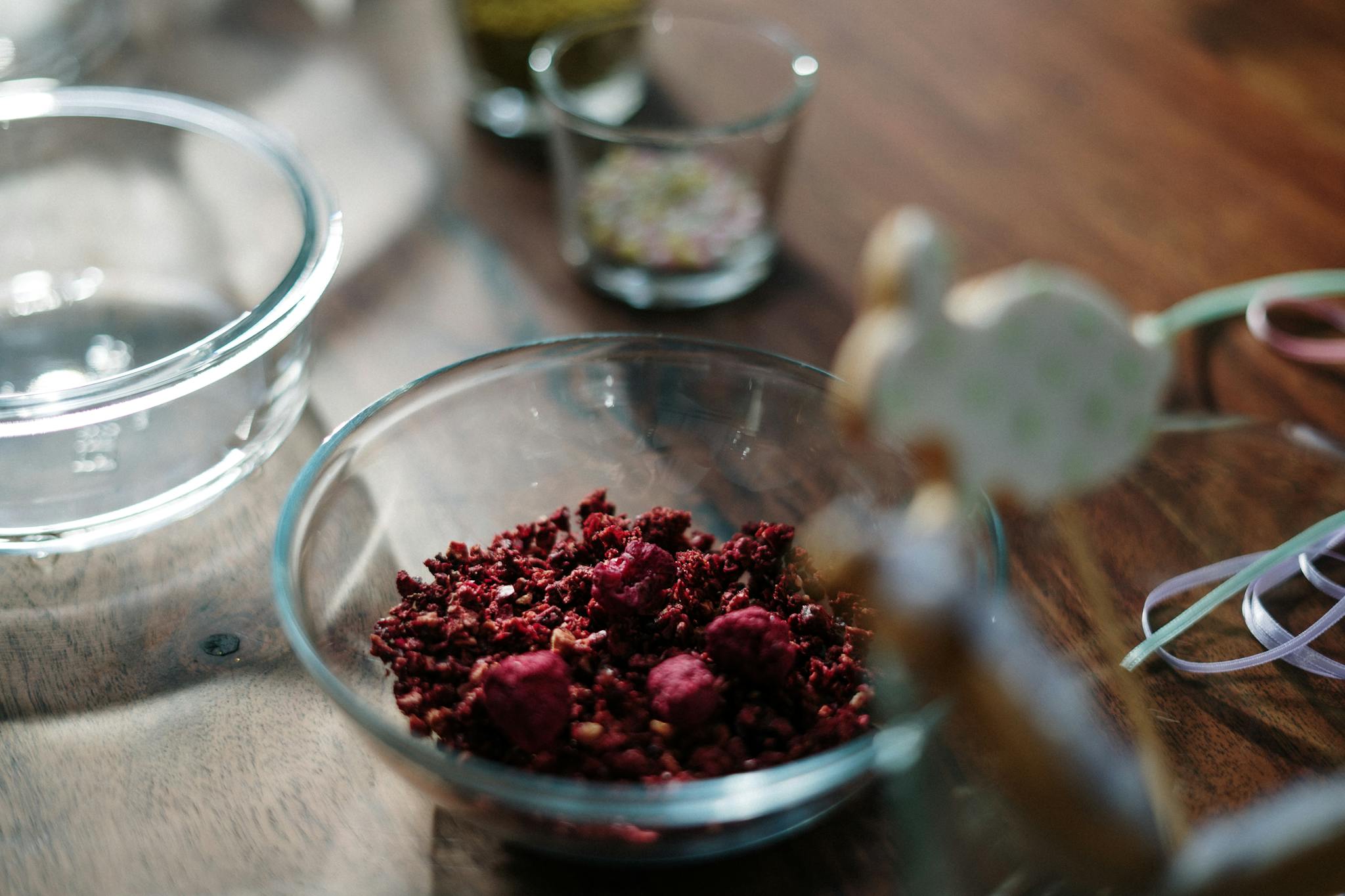 Colorful Easter cake ingredients in glass bowls on a wooden table, perfect for festive decor.
