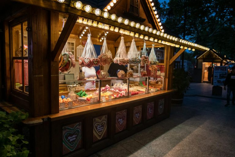 Explore Berlin's vibrant night market with a cozy sweets stall, offering traditional treats and festive lights.